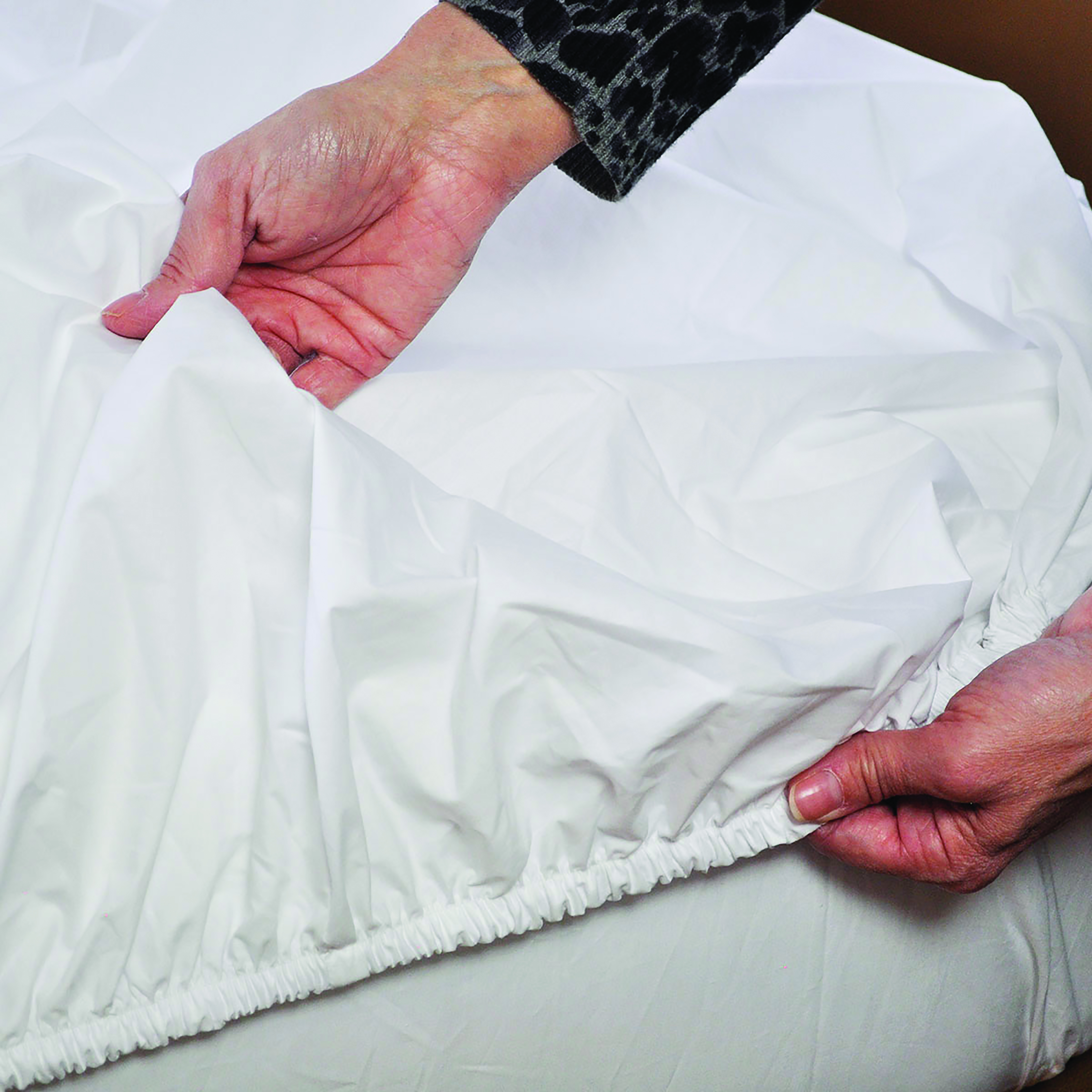 putting fitted sheet on bed